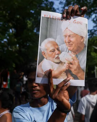 A man holds an image depicting US President Donald Trump and Indian Prime Minister Narendra Modi during a protest in New Delhi on July 24. Photo: Reuters