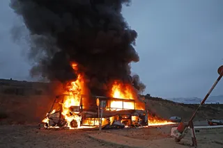 7月31日，在摩洛哥边境城镇菲尼代克冲突地点附近，一辆车子被烧毁。（法新社）