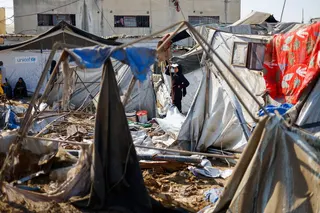 A woman stands near tents sheltering displaced Palestinians, following an overnight Israeli strike on a medicine warehouse, according to medics, in Deir al-Balah, in the central Gaza Strip, August 1, 2026., residents had been pre-warned by the Israeli military to evacuate. REUTERS/Mahmoud Issa