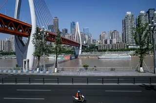 A man rides his motorcycle along a street in Chongqing July 21, 2026. — AFP pic