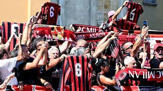 AC Milan fans gather to hold aloft black and red scarfs, banners and club jerseys bearing Franco Baresi's number six