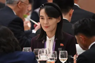 Kim Yo Jong sat at a table with glasses of drink in front