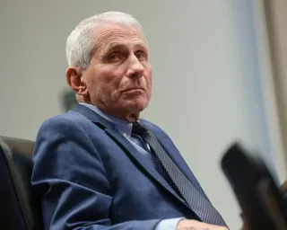 a man in a suit looks off to the side while seated