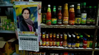 在與緬甸接壤的泰國湄索，緬甸醬料和調味品的瓶子旁掛著一張印有翁山蘇姬照片的月曆。