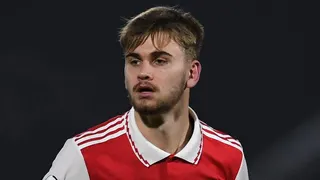 Billy Vigar looking on in a red Arsenal kit