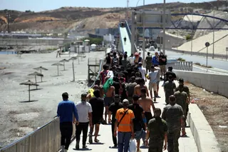 A group of migrants approach the border post to make their way back to Morocco, escorted by Spanish infantry soldiers, in the Spain's north African enclave of Ceuta, on August 2, 2026. — AFP pic