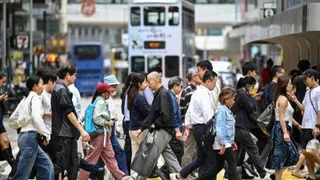 图为2月25日在香港中环，行人穿过繁忙的十字路口。（法新社档案照）