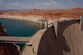 People walk across the Glen Canyon Dam near Lake Powell at the Glen Canyon National Recreation Area, Tuesday, July 14, 2026, near Page, Nev. (AP Photo/John Locher)