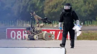 A police investigator works on the tarmac with a robot capable of defusing explosives near a Ukrainian Antonov cargo plane at Leipzig/Halle Airport on August 5, 2026 near Leipzig, Germany