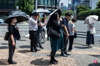 日本天气炎热，图为东京民众街头打伞。 （法新社）