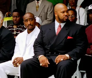 Tupac Shakur and Marion ‘Suge’ Knight sitting in suits