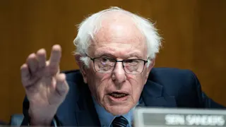 A person in glasses gestures with their hands