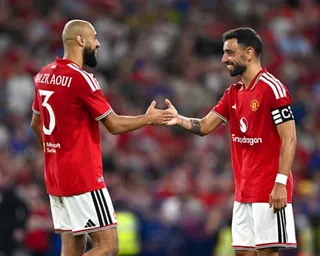 Noussair Mazraoui and Bruno Fernandes smile and shake hands