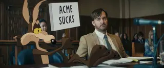 Wile E. Coyote hold a sign that reads "ACME sucks"