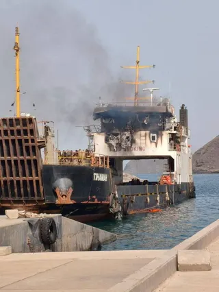 Smoke rising from a damaged cargo ship