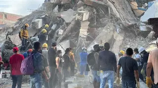 Rescuers and civilians at a mountain of rubble in Cali