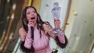 Bulgarian singer Dara has long dark hair and is wearing a pink top, holding a trophy.