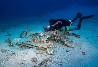 Kingo Wakasa photographs the kamikaze plane wing section he discovered at the USS Emmons wreck site.