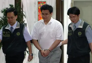 2006年6月2日，台灣總統陳水扁的女婿趙建銘（中）在台北辦公室接受調查局人員的訊問後被帶走。陳水扁總統所在的民進黨因涉嫌內幕交易而陷入動盪，其女婿趙建銘被指控牽涉其中。該指控引發了對陳水扁家族的強烈批評。