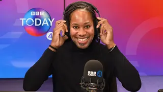 Holding headphones on his head, BBC Radio 4 Today Christmas guest editor Prof Jason Arday smiles at the camera in the studio.