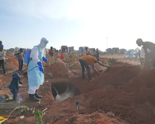 A health worker sprays disinfectant in a freshly dug grave of someone who died of Ebola, in Bunia, Democratic Republic of the Congo