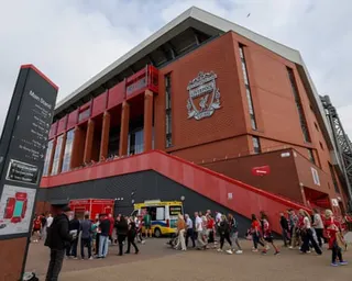 Fans gather outside Anfield stadium's Main Stand entrance before a match