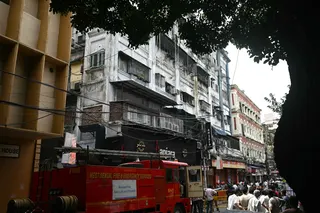 Onlookers and fire personnel gather in the aftermath of a fire at a hotel in Kolkata on Wednesday. Photo: AFP