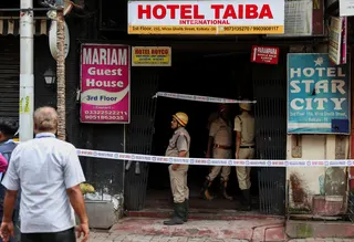 Firefighters stand at an entryway to a hotel where a fire broke out and killed several people, in Kolkata on Wednesday. Photo: Reuters