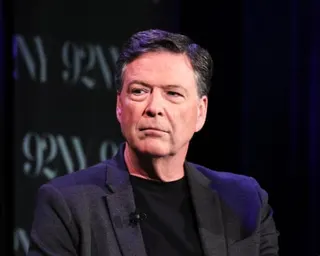 a man in a dark suit jacket looks to the side