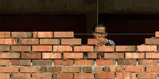 A bricklayer builds a wall at a construction site in Kuala Lumpur