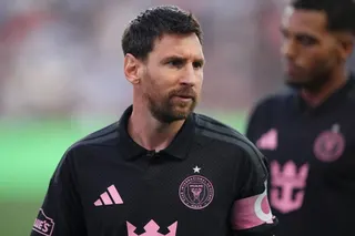 A football player stands on the pitch.