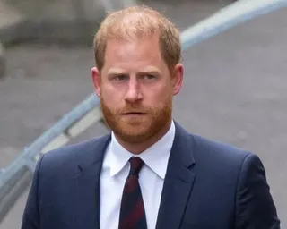 Prince Harry, in a navy suit, outside a courthouse