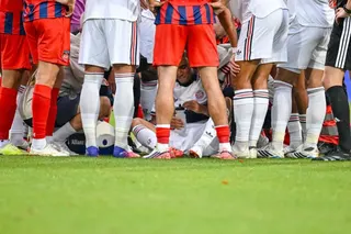 Bayern Munich’s Jamal Musiala, bottom, receives treatment after collapsing