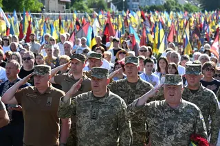 Ukrainian military members and others sing the country’s national anthem as they pay tribute to fallen Ukrainian soldiers at Lychakiv Cemetery in Lviv on Monday. Photo: AFP