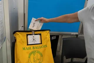 a person mailing a ballot