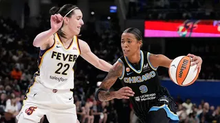 Natasha Cloud drives against Caitlin Clark during a WNBA basketball game.