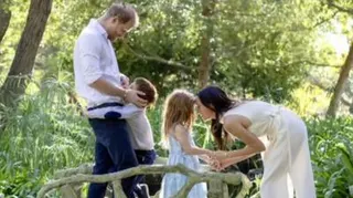 Prince Harry and his wife and children pose in a sunlit garden