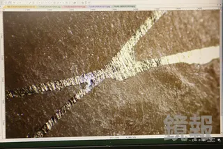顯微觀察軟玉手鐲上的「錯金」，可見鍍金脫落後裸露出銅鎳合金，且工藝粗糙。李鍾泉攝