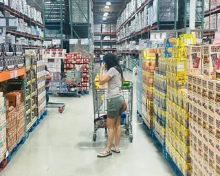 a shopper stands in an aisle with a cart