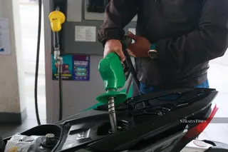 A man refills his motorcycle with RON97 petrol. NSTP FILE PIC, FOR ILLUSTRATION PURPOSES ONLY