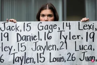 Meta被美国29个州联合起诉，指刻意设计平台，让年轻用户上瘾。图为一名女子8月18日在加州奥克兰的法院外举起横幅示威，上面写着将近400名据称因受社媒影响而死亡的年轻人姓名。 （法新社）
