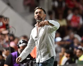 Coach Kily González gestures and shouts on the sideline during a soccer match