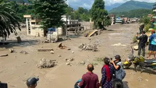 尼泊尔与中国西藏自治区边境周三上午爆发大规模土石流，大量泥沙、岩石与洪水沿河谷倾泻，瞬间冲走车辆及建物。（图取自法新社）