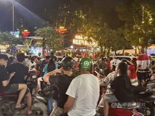 東協盃足球錦標賽26日決賽期間，有大螢幕轉播的店家，門口、人行道上停滿機車、站滿人，享受一起看球賽的氣氛，甚至占據部分機車道，但店家也不以為意，因為這是越南人的凝聚時刻。中央社記者曾婷瑄河內攝　115年8月27日