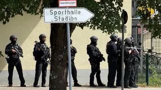 Police officers stand with guns outside a school in Germany.