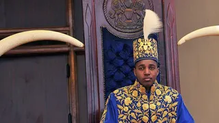 King Oyo pictured at 18 during his coronation wearing a gold embroidered jacket and hat.