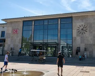 People walking outside Rosenheim's train station on a sunny day