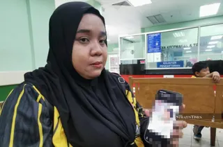 Puteri Anis Athirah shows a photograph of her son receiving treatment at Sultanah Nur Zahirah Hospital. PIC BY NSTP/NAZDY HARUN