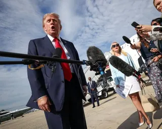a man in a suit speaks to the press