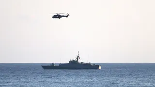 A helicopter and a vessel operate near the area where a passenger boat capsized off the coast of Kyrenia in northern Cyprus